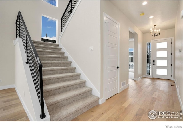 entrance foyer with an inviting chandelier and light wood-type flooring