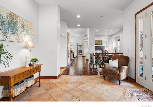 foyer entrance featuring a tile fireplace and light hardwood / wood-style flooring