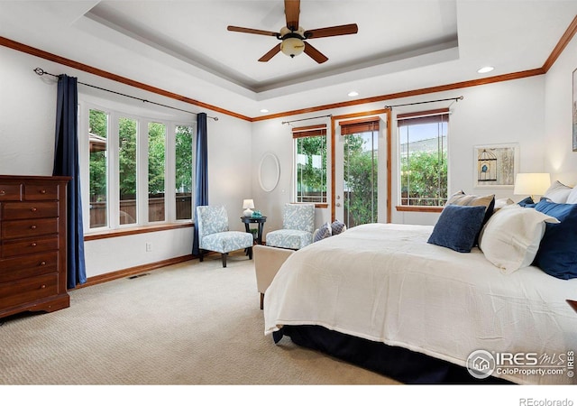 carpeted bedroom with ceiling fan, a raised ceiling, and crown molding