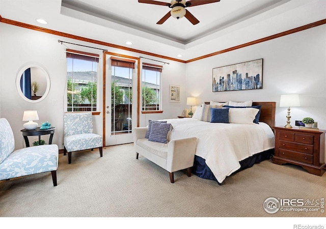 bedroom featuring a raised ceiling, ceiling fan, light carpet, and access to outside