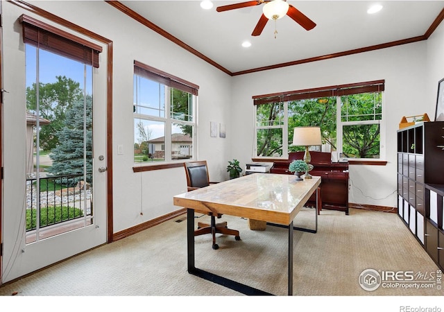 carpeted home office with crown molding, plenty of natural light, and ceiling fan