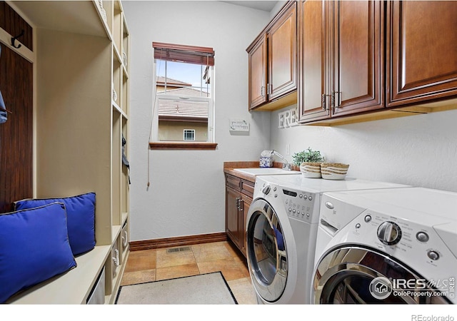 laundry area with cabinets, light tile patterned floors, independent washer and dryer, and sink