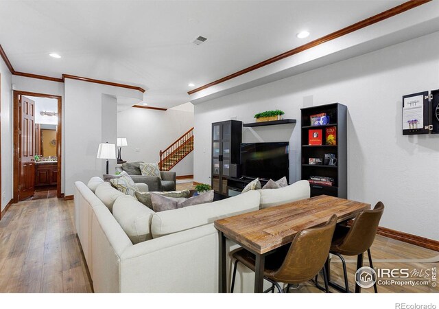 living room with ornamental molding and wood-type flooring