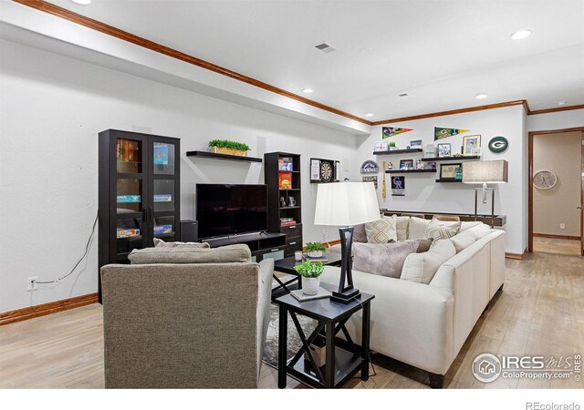 living room with light wood-type flooring and ornamental molding