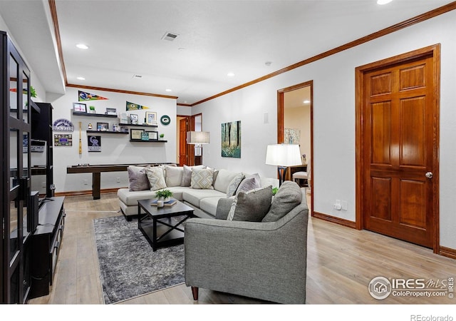 living room featuring ornamental molding and light hardwood / wood-style floors