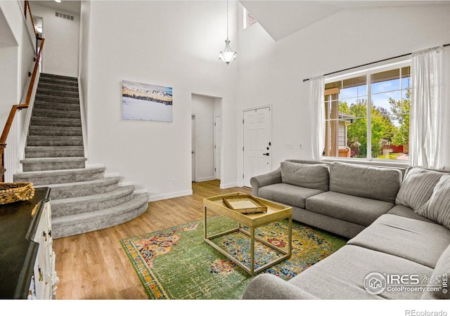 living room featuring high vaulted ceiling and wood-type flooring