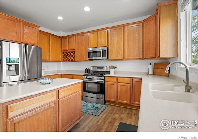 kitchen featuring appliances with stainless steel finishes, light hardwood / wood-style floors, and sink