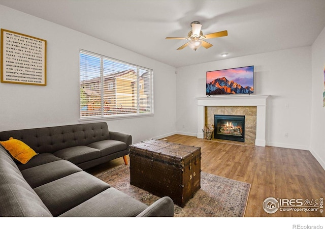 living room with ceiling fan, hardwood / wood-style flooring, and a fireplace