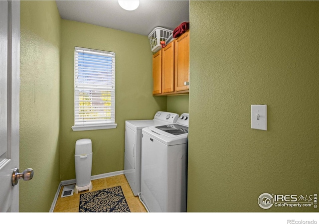 laundry room with separate washer and dryer, cabinets, and light tile patterned flooring