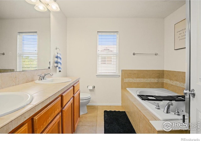 bathroom with a wealth of natural light, tiled bath, toilet, and vanity