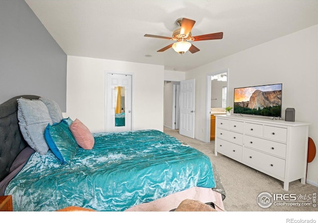 carpeted bedroom featuring ensuite bath and ceiling fan