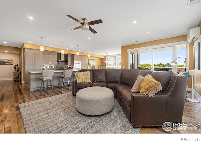 living room featuring a wall mounted AC, dark wood-type flooring, and ceiling fan