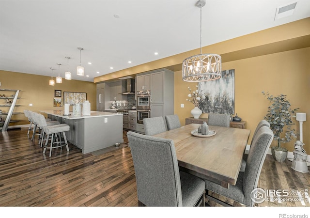 dining space with dark wood-type flooring and a chandelier