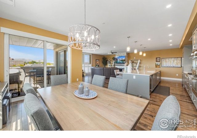 dining room with sink, hardwood / wood-style floors, and a notable chandelier