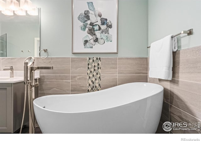 bathroom with vanity, tile walls, and a washtub