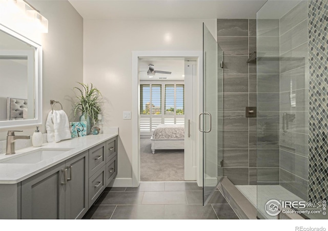 bathroom with tile patterned flooring, walk in shower, ceiling fan, and vanity