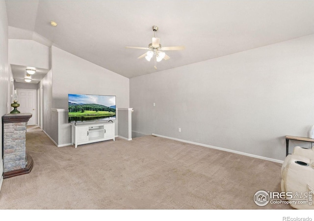 carpeted living room with vaulted ceiling, ceiling fan, and a fireplace