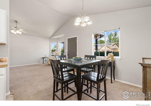 carpeted dining room featuring ceiling fan with notable chandelier, lofted ceiling, and a healthy amount of sunlight