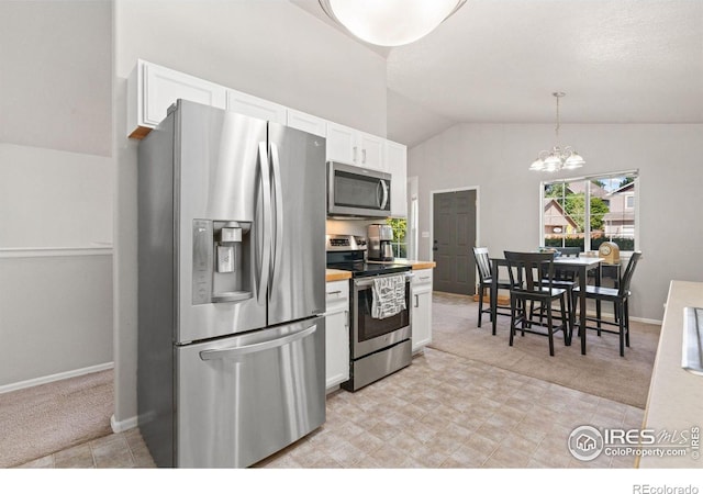 kitchen with decorative light fixtures, white cabinets, stainless steel appliances, and light carpet