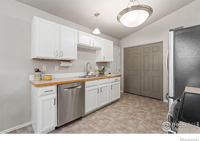 kitchen featuring decorative light fixtures, appliances with stainless steel finishes, white cabinetry, sink, and wooden counters