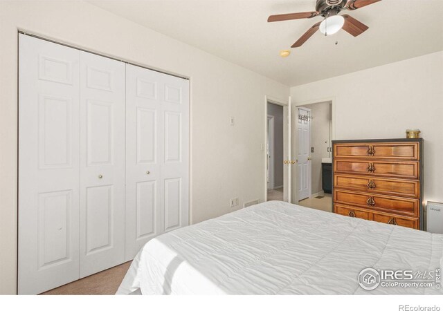 carpeted bedroom featuring a closet and ceiling fan