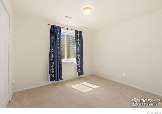 unfurnished room featuring light colored carpet