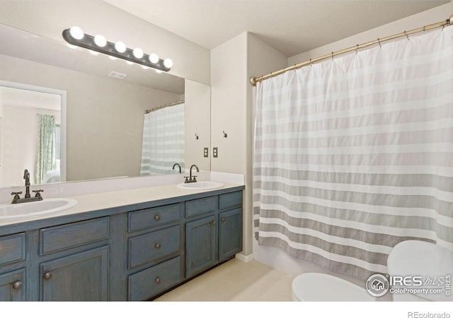 bathroom featuring vanity, toilet, and curtained shower