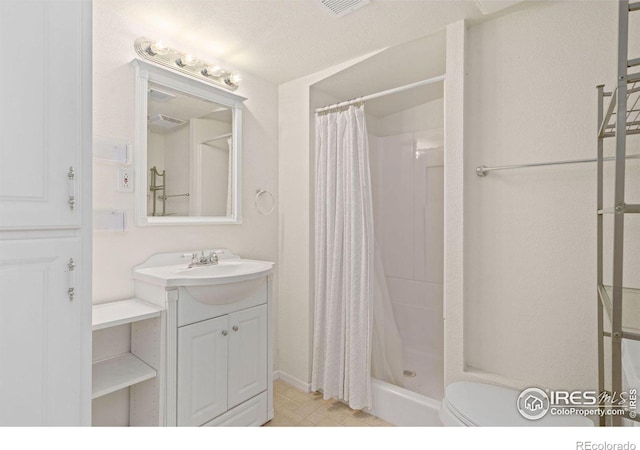 bathroom featuring a textured ceiling, vanity, toilet, and a shower with curtain