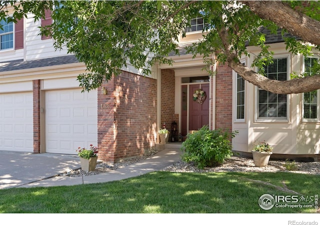 property entrance with a lawn and a garage