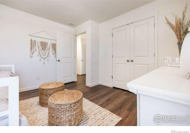 bedroom with a closet and dark hardwood / wood-style floors