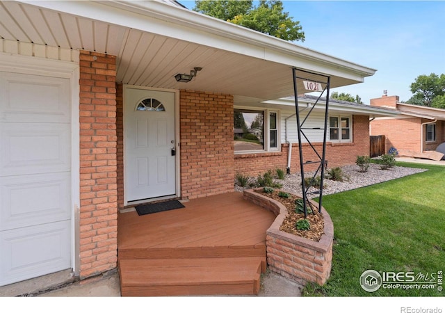 property entrance with a lawn and covered porch