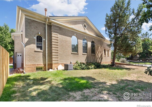 exterior space with central AC, a yard, and a garage