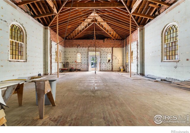 misc room with high vaulted ceiling and concrete floors