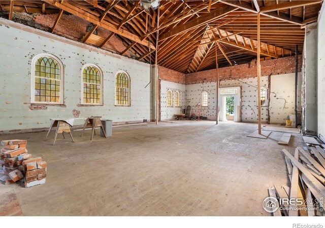 miscellaneous room featuring lofted ceiling and concrete floors