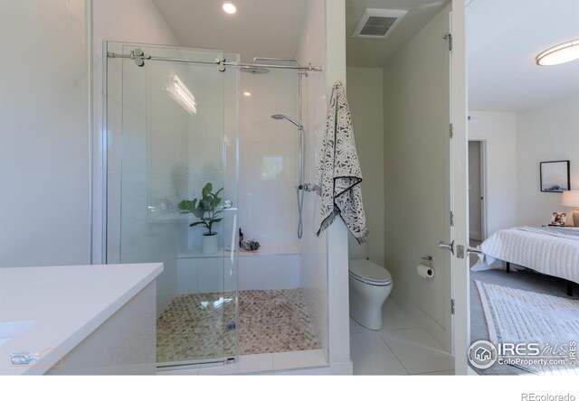 bathroom featuring vanity, toilet, walk in shower, and tile patterned floors