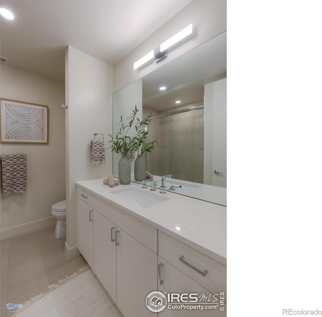 bathroom with tile patterned floors, toilet, a shower with door, and vanity