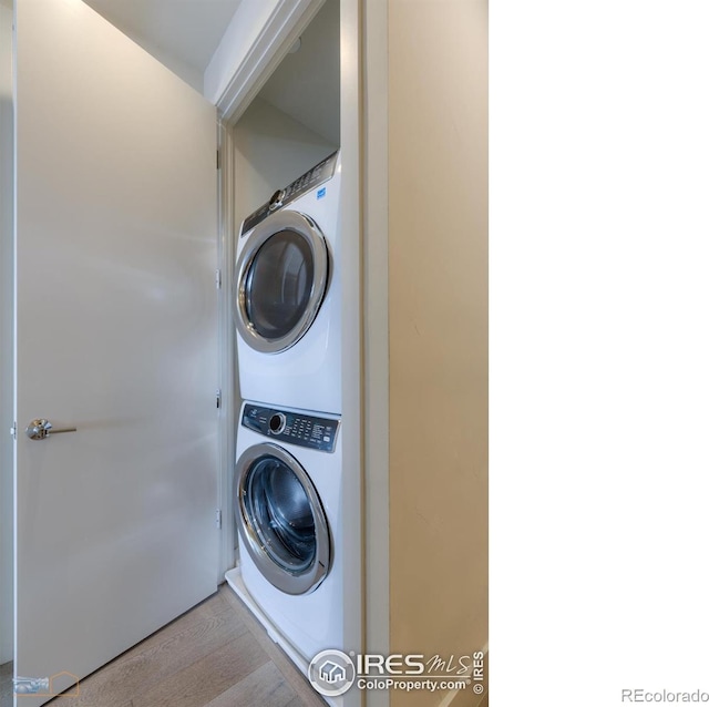 washroom featuring light wood-type flooring and stacked washer and clothes dryer