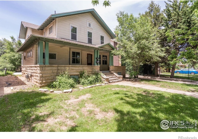 view of front of house with covered porch and a front lawn