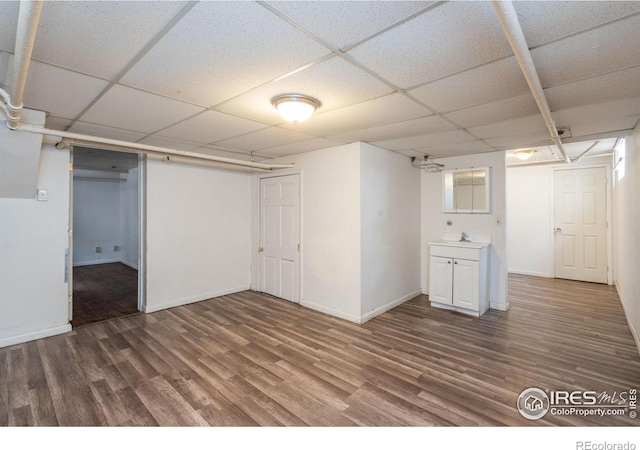 basement featuring hardwood / wood-style flooring, sink, and a drop ceiling