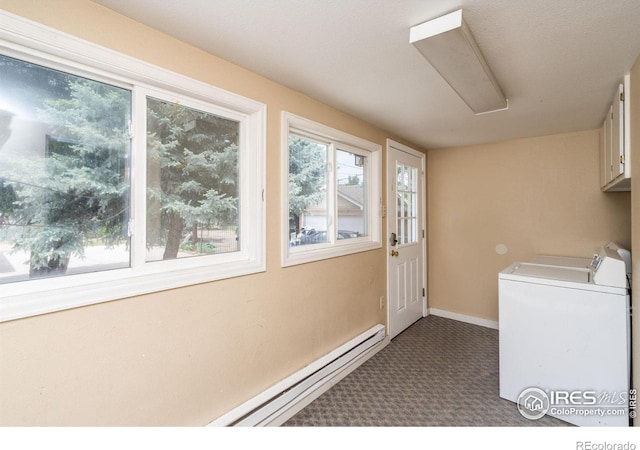 washroom featuring washer and clothes dryer, dark colored carpet, baseboard heating, and cabinets