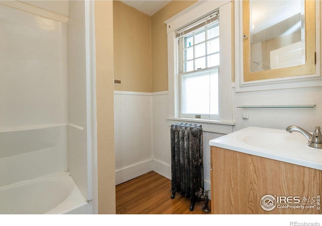 bathroom with vanity, radiator, and hardwood / wood-style flooring