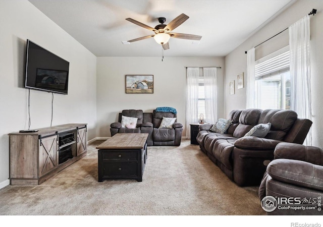 carpeted living room with ceiling fan