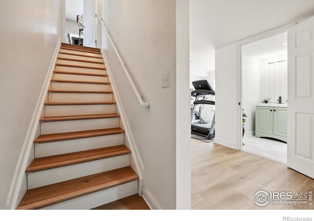 stairway featuring sink and wood-type flooring