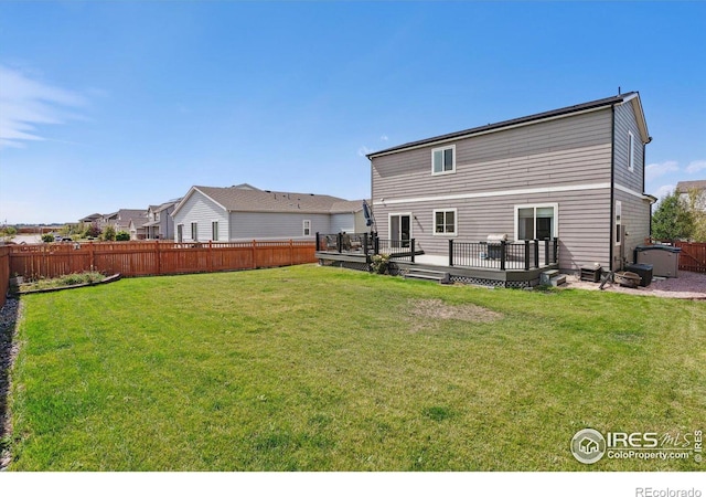 rear view of house featuring a yard and a wooden deck