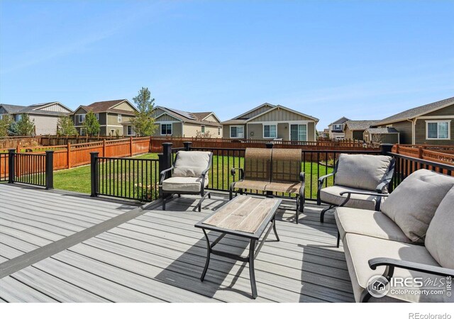 wooden terrace with a yard and outdoor lounge area