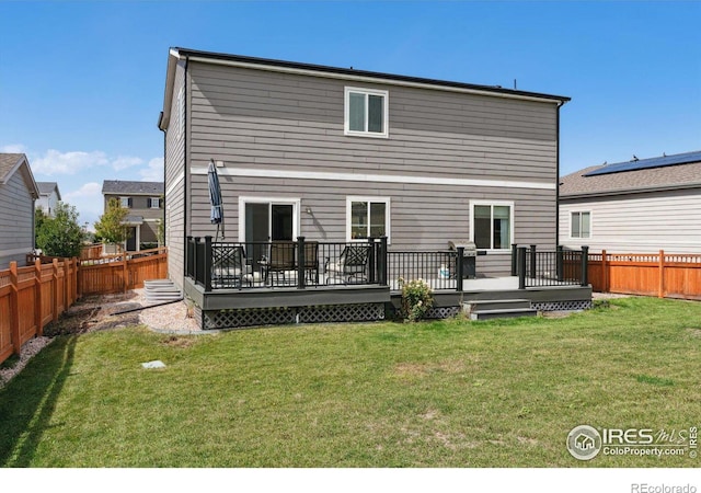 back of house featuring a deck and a yard