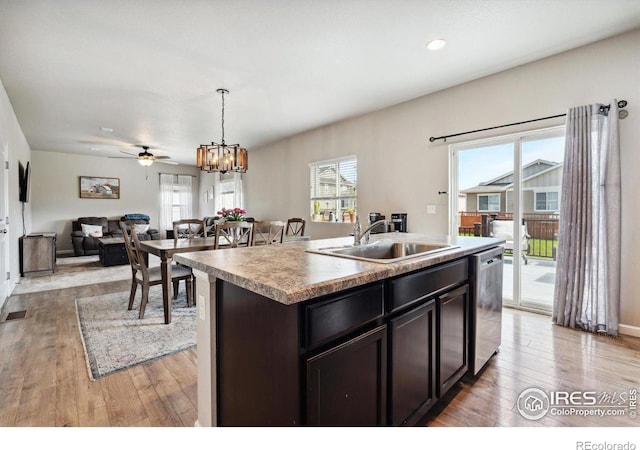 kitchen with dishwasher, decorative light fixtures, a kitchen island with sink, ceiling fan with notable chandelier, and sink