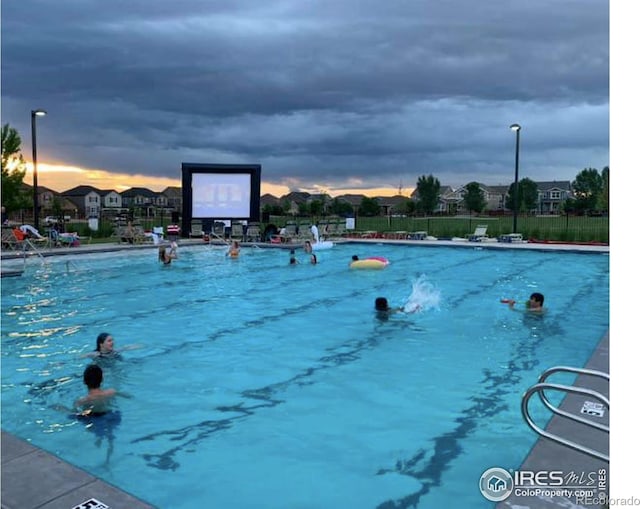 view of pool at dusk