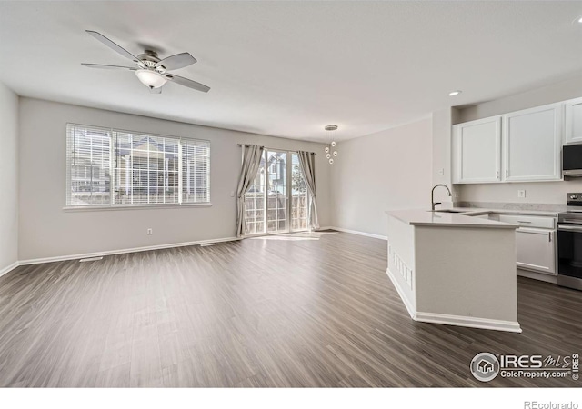 kitchen with appliances with stainless steel finishes, white cabinets, dark hardwood / wood-style flooring, ceiling fan, and sink