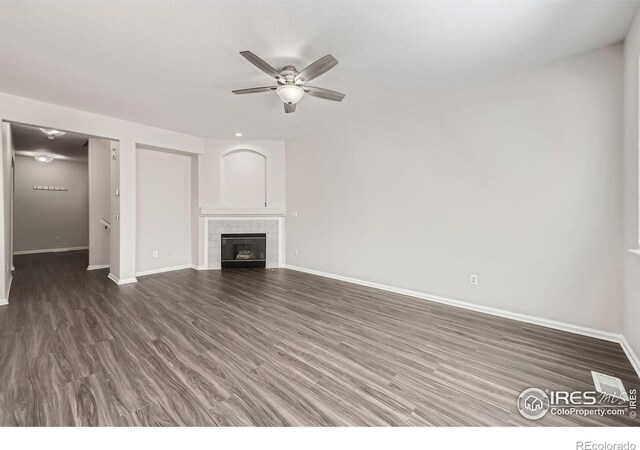 unfurnished living room with ceiling fan, dark hardwood / wood-style floors, and a fireplace